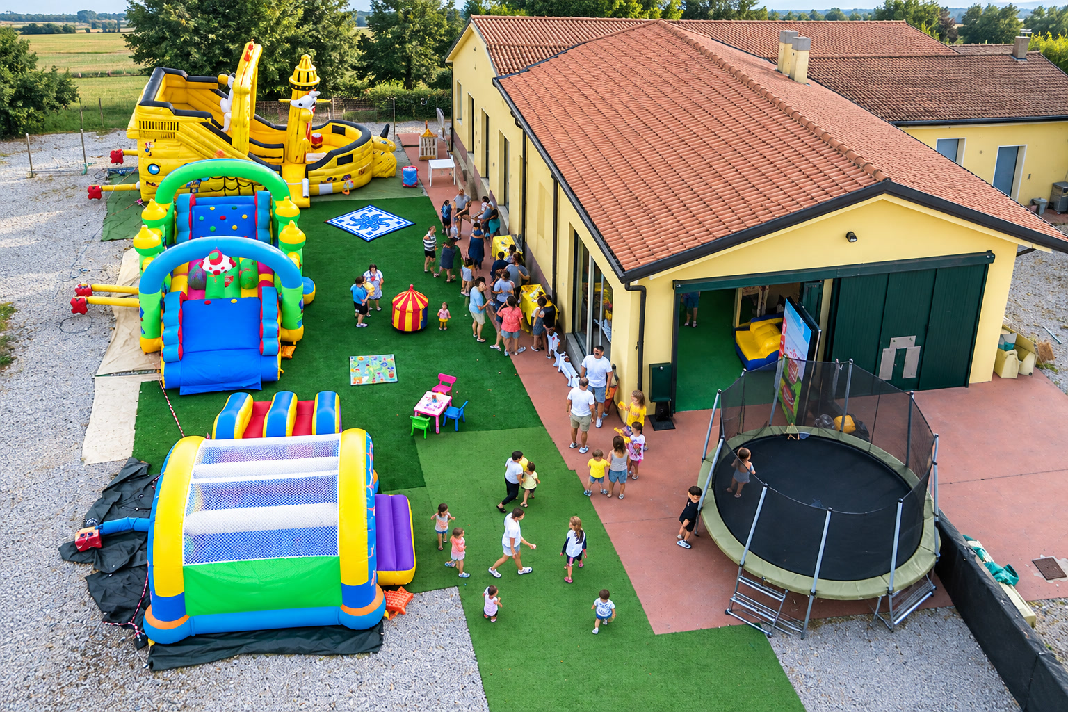 Vista obliqua degli spazi esterni Giò Party con gonfiabili, sala e trampolino