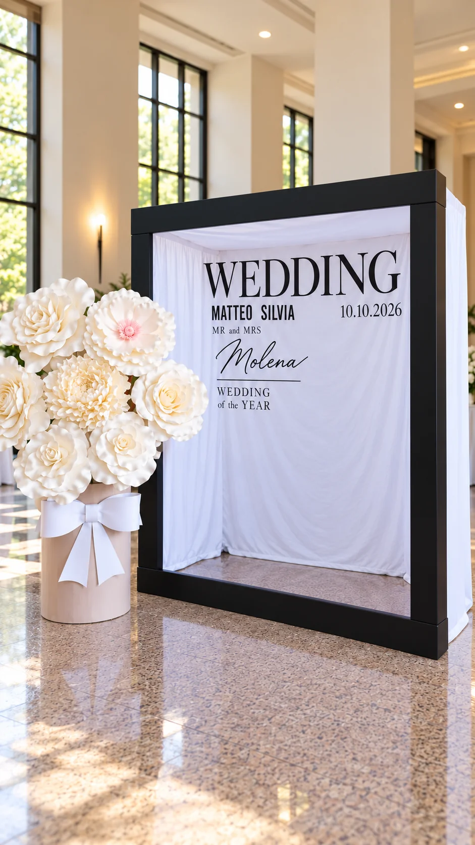 Variante del photobooth con grandi fiori avorio, fiocco bianco e fondale personalizzato